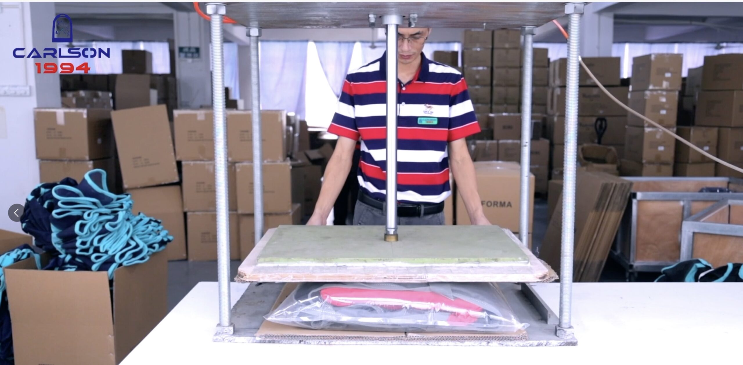 Industrial hydraulic compression and vacuum packing machine sealing bulk equestrian products for safe ocean freight.